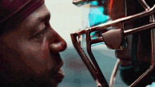 a man wearing a headband looks at another man wearing a helmet