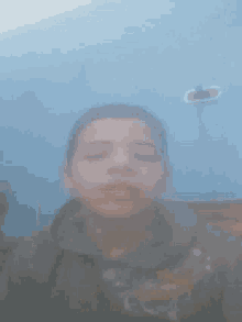 a blurry picture of a man 's face with his eyes closed against a blue wall