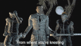 a man in a plaid suit is surrounded by two men with the words from where you 're kneeling written below him