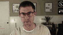 a man wearing glasses and ear buds is looking at the camera