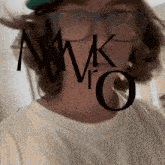 a man wearing glasses and a white shirt has the letters mmk and ro on his face