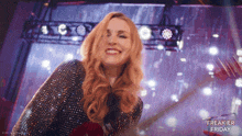 a woman is smiling on a stage with freakier friday written in the corner