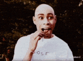 a bald man wearing a white shirt that says golf