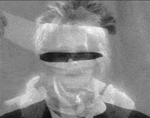 a black and white photo of a man with sunglasses on his face