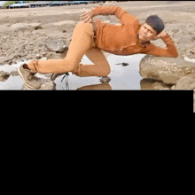 a man is laying on his stomach in a puddle with the letter g on the bottom right