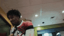 a man wearing a red white and black jersey with a toronto raptors logo on it