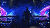 a wrestler is walking on a stage with the aew logo on the screen