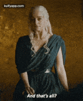 a woman in a green dress is standing in front of a wall and says and that 's all .