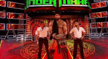 a wrestler is standing on a red carpet in front of the undertaker sign