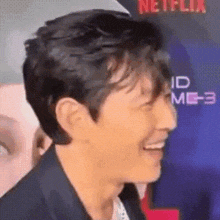 a close up of a man 's face with a blurred background and a netflix logo in the background .