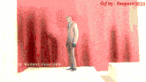 a gif by reaper # 3533 shows a man standing in front of a wall