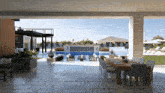 a patio with a table and chairs and a swimming pool in the background