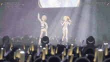 two anime girls are performing on a stage with a sign that says laki mode on it