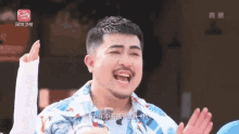 a man with a beard is laughing in front of a s logo