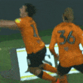 a soccer player is jumping in the air while another player watches