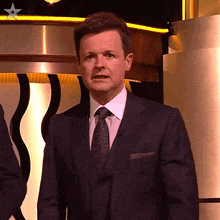 a man in a suit and tie with a star on his chest