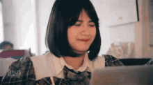 a woman sitting in front of a laptop with males banget.com written on the bottom of the screen