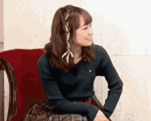 a woman is sitting in a chair with her hands on her hips .