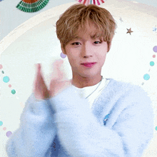 a young man in a blue sweater is clapping