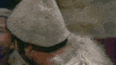 a man wearing a white hat with a furry beard