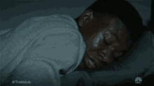 a man laying on a bed with the hashtag thisisus