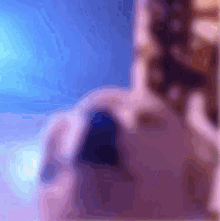 a blurry image of a person 's face with a blue background