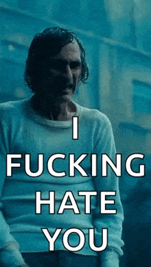 a man in a white sweater with the words i fucking hate you on it