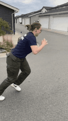 a man wearing a blue shirt with the word army on it is running down a street