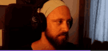 a man with a beard is wearing headphones and a headband on his head .
