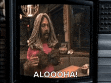 a man with dreadlocks is on a television screen with the words aloooha on it .