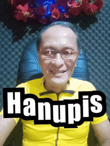 a man wearing glasses and a yellow shirt has the word hanupis on his shirt
