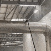 a person is cleaning a pipe in a warehouse with a hose .