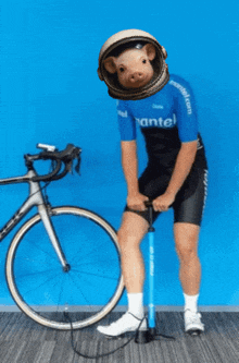 a man wearing a blue shirt that says mantel pumps his bicycle tire