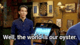 a man standing in front of a dart board with the words well the world is our oyster