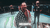 a man in a boxing ring holding an american flag with the words we own u on the bottom