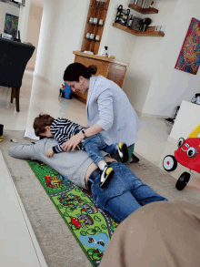 a woman is laying on the floor with a child on her lap