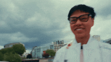a man wearing glasses and a white jacket with the letter v on the front