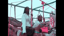 a couple of women are riding a merry go round at a carnival .