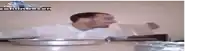 a man in a white shirt is sitting at a table with an ashtray on it