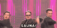 three men are dancing in front of a pink background and the word sauna is on the screen