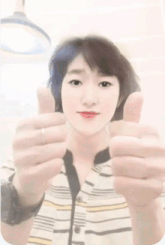 a woman is giving a thumbs up sign with both hands