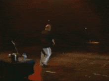 a man in a black shirt is singing on stage
