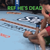 a wrestling match with the words ref he 's dead on the top