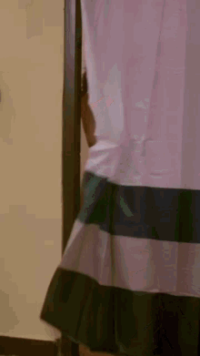 a woman in lingerie is standing in a doorway holding a curtain .