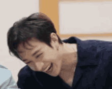 a close up of a person laughing while sitting down .