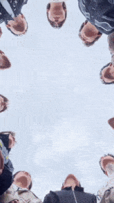 a group of men are standing in a circle and looking up at the sky