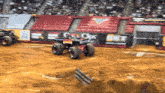 a monster truck is driving on a dirt track in front of a banner that says bkt