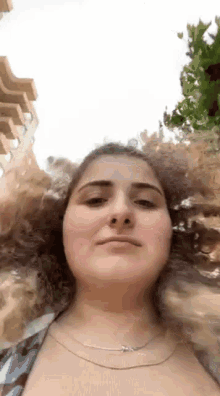 a woman with curly hair is making a funny face while looking at the camera .