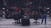 a group of men wearing black shirts with the word staff on them are standing in a circle .