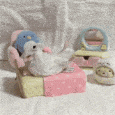 a stuffed animal with a penguin on it sits next to a stuffed animal with a bear on it